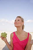 Content woman holding bunch of grapes