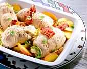 Turkey roll with dried fruit and bacon in serving dish