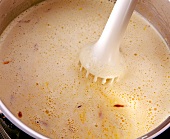 Close-up of cream cheese mixed with hand mixer