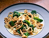 Noodles with spinach, onions and cheese on plate