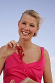 Laughing woman holding a bunch of red currants