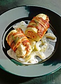 Stuffed braised bacon and white sauce on black dish