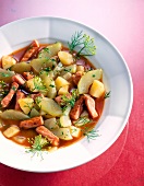 Braised stew with smoked pork, potatoes, onions and herbs on dish