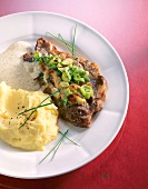 Baked neck chops with onions, mashed potatoes and mustard sauce on dish