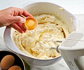 Egg yolk being mixed with dough in bowl