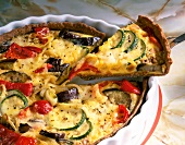 Vegetable tart with eggplant, peppers, onions and cheese in bowl