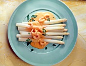 Asparagus with lobster cream sauce and shrimp on blue dish