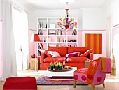 Wohnzimmer mit Bücherregal, Sofa und Sessel in orange-rot