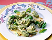 Gnocchi with herbs and pine nuts on plate