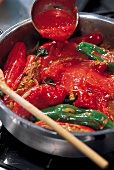 Curry, Tomatensauce zu den gefüllten Paprikaschoten gießen, Step