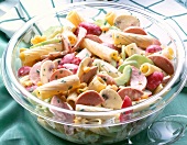 Close-up of pasta salad with sausage in glass bowl