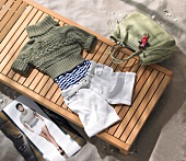 Green knitted sweater, striped t-shirt and white shorts on wooden deck
