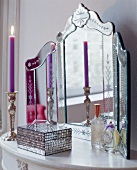 Three piece dressing table with mirror on white mosaic box and lit candle in front