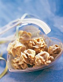 Close-up of white chocolate with orange crossies in heart shaped bowl