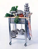Küchenwagen mit Gemüse und verschiedenen Kochtöpfen.