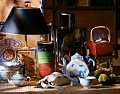 Asian tea cups, teapots and small floor lamp on woven mat