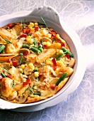 Close-up of potato and vegetable casserole with corn, peas, beans, mushrooms and rosemary