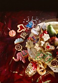 Close-up of Christmas cookies on plate and scattered on red tablecloth