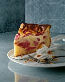 Rhubarb cake with vanilla cast, almonds and cream on plate