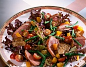 Close-up of salad with duck breast and mushrooms on plate