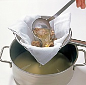 Filtering poultry stock through cloth sieve in bowl, step 8