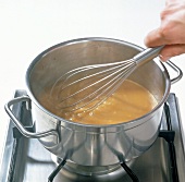 Hand stirring the mixture with whisk in saucepan, step 4