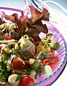Close-up of beef salad with artichokes, tomatoes and olives in bowl