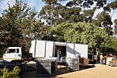 Men loading wooden crate with wine bottles in truck at Beaumont Winery, South Africa