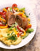 Close-up of roulades with peppers, spring onions, chives and mashed potatoes on plate