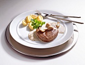 Wild; Hirschsteak mit Steinpilzsauce und Gnocci auf Teller