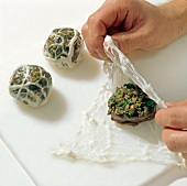 Medallions being wrapped in pork caul, step 1