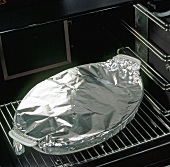 Baking dish covered with aluminium foil placed in oven, step 6
