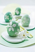 Close-up of Easter eggs with floral print next to white flower