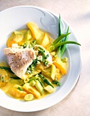 Close-up of redfish fillet with apricots, green onions and curry on plate