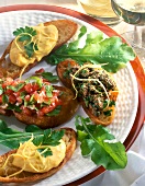 Close-up of crostini with chicken liver, ailoi and tomatoes on plate