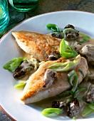Close-up of chicken breast in morel sauce with leeks on plate