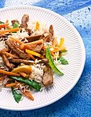 Close-up of vegetable rice stir fry with pork on plate
