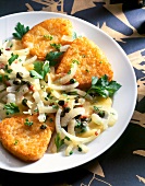 Close-up of rash browns with onion vegetables, capers, parsley and cheese on plate