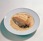 Raw duck leg in breadcrumbs on plate, step 3