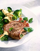 Close-up of stuffed steak with broccoli on plate