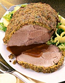 Close-up of roast pork with mustard crust on plate
