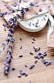 Bath additive and lavender flowers on bamboo mat