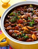 Close-up of midnight soup with beef, tomatoes, mushrooms and leek in serving dish