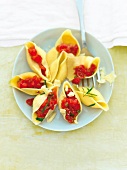 Conchiglie pasta filled with melted tomatoes on plate