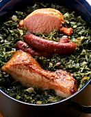 Close-up of smoked sausage with kale and cabbage