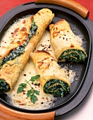 Close-up of pancake filling with spinach on serving dish