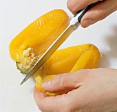 Close-up of hands cutting yellow pepper, step 4