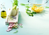 Fennel on cutting slicers with radish and oil in carafe