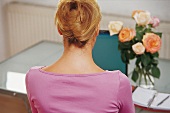 Relax-Massagen -Rückansicht: Blonde Frau, rosa Pulli,Schreibtisch