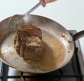 Close-up of adding butter on beef in frying pan, step 2